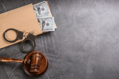 Flat lay composition with dollar bills in envelope and space for text on grey stone table. Bribe concept