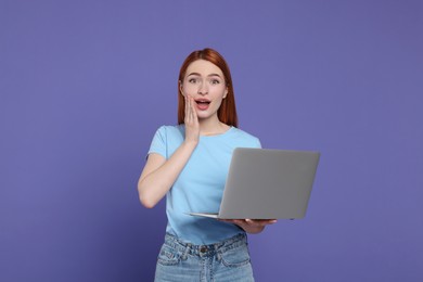 Photo of Surprised young woman with laptop on lilac background