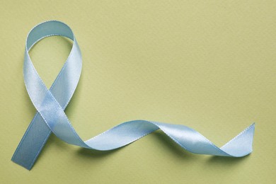 International Psoriasis Day. Ribbon as symbol of support on green background, top view. Space for text