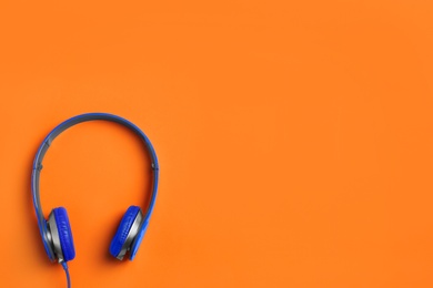 Stylish headphones on color background, top view. Space for text