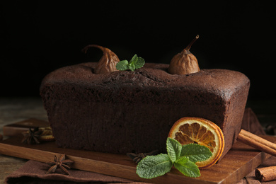 Photo of Tasty pear bread with mint and dried orange slice on table. Homemade cake