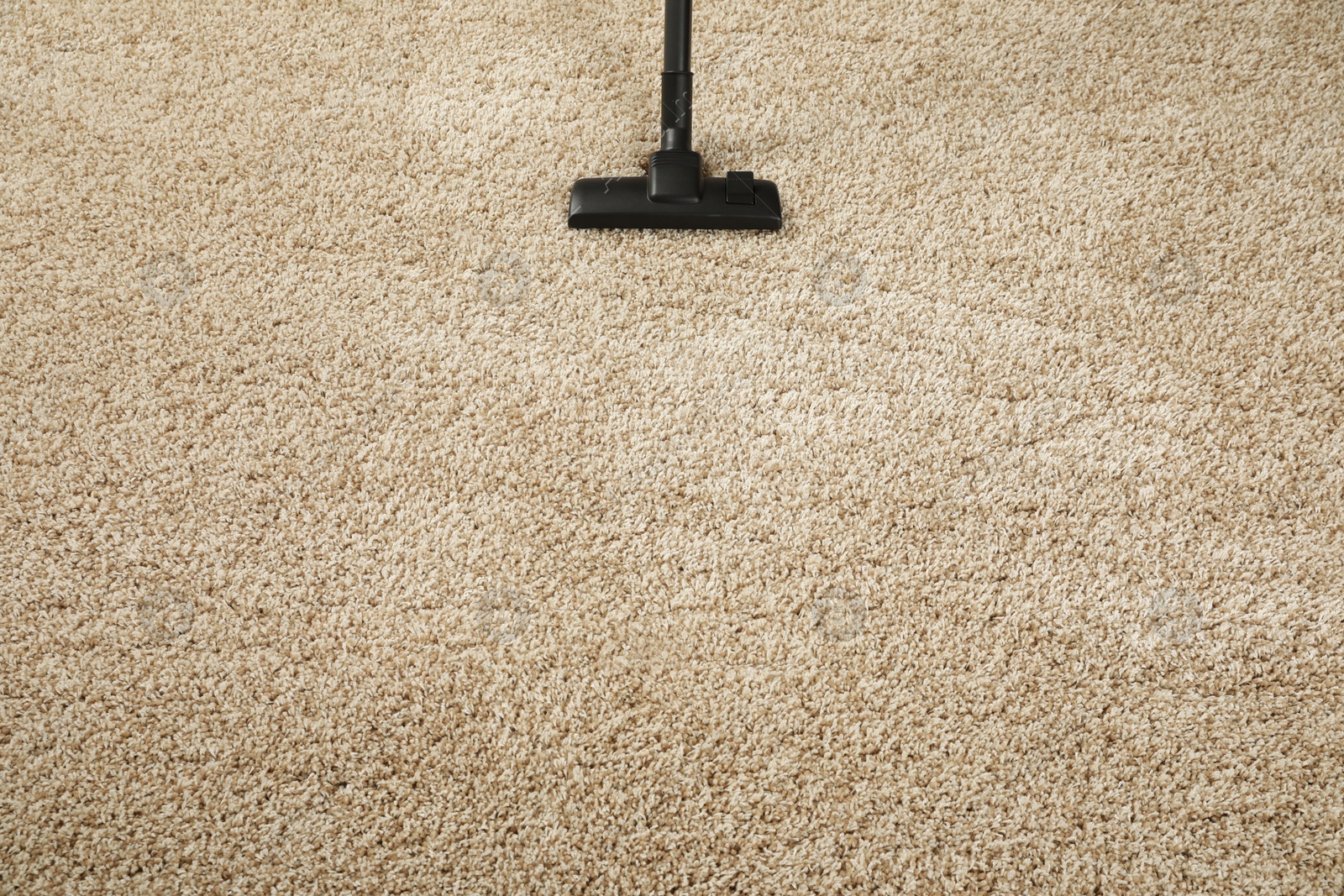 Photo of Removing dirt from beige carpet with modern vacuum cleaner. Space for text