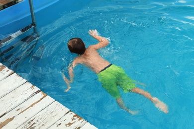 Photo of Little child in outdoor swimming pool. Dangerous situation