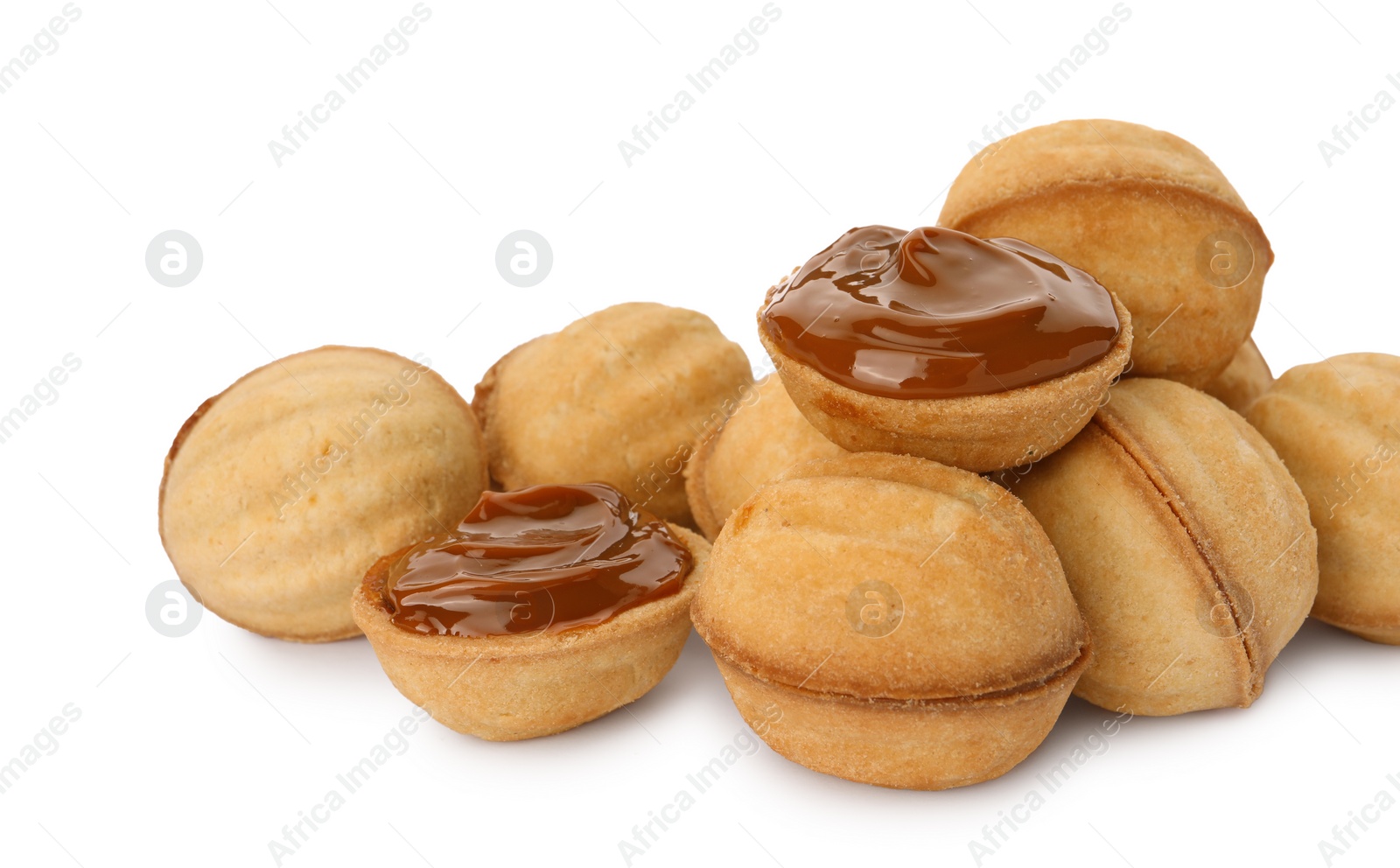 Photo of Delicious nut shaped cookies with boiled condensed milk on white background