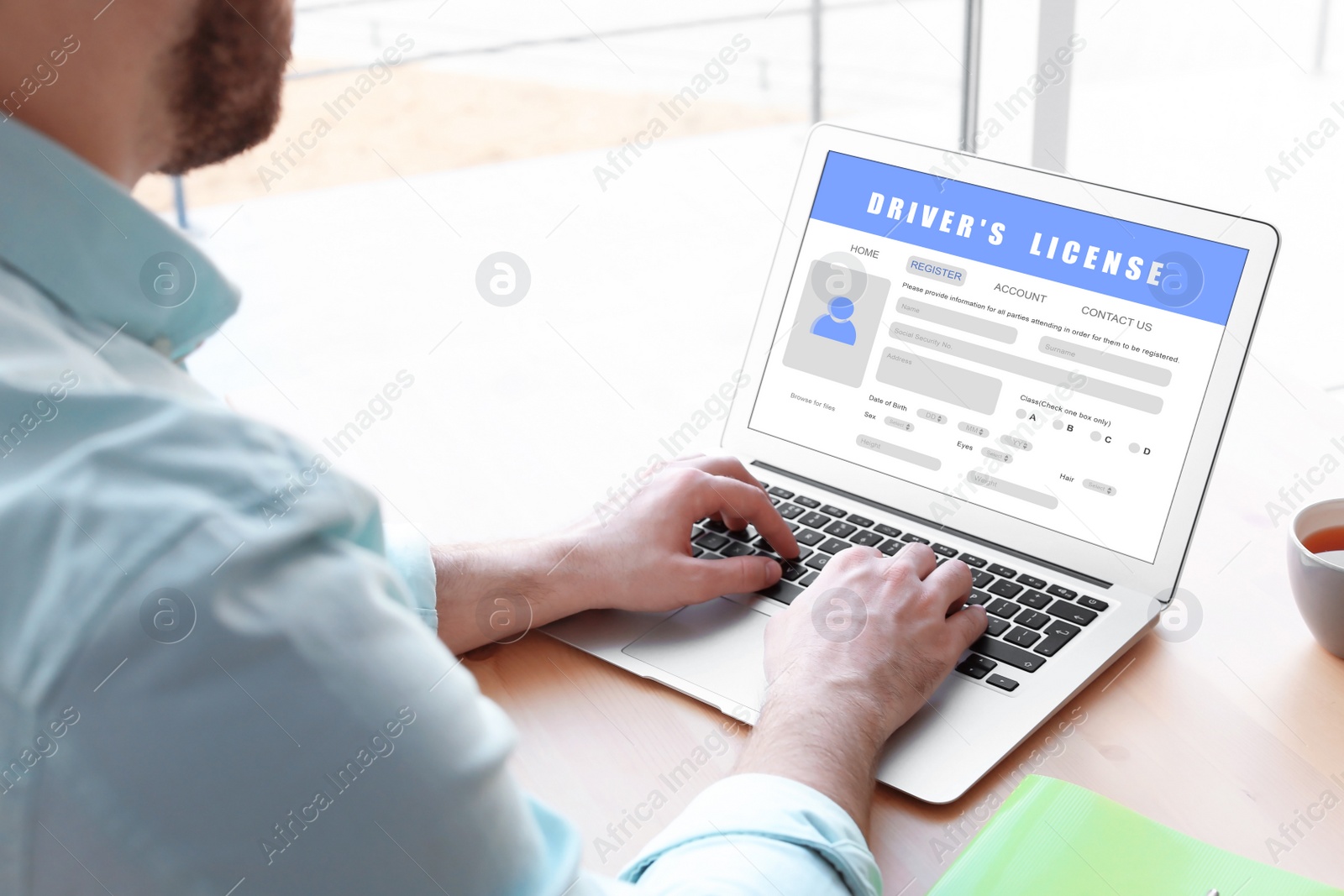 Image of Man filling in driver's license form online on website using laptop, closeup