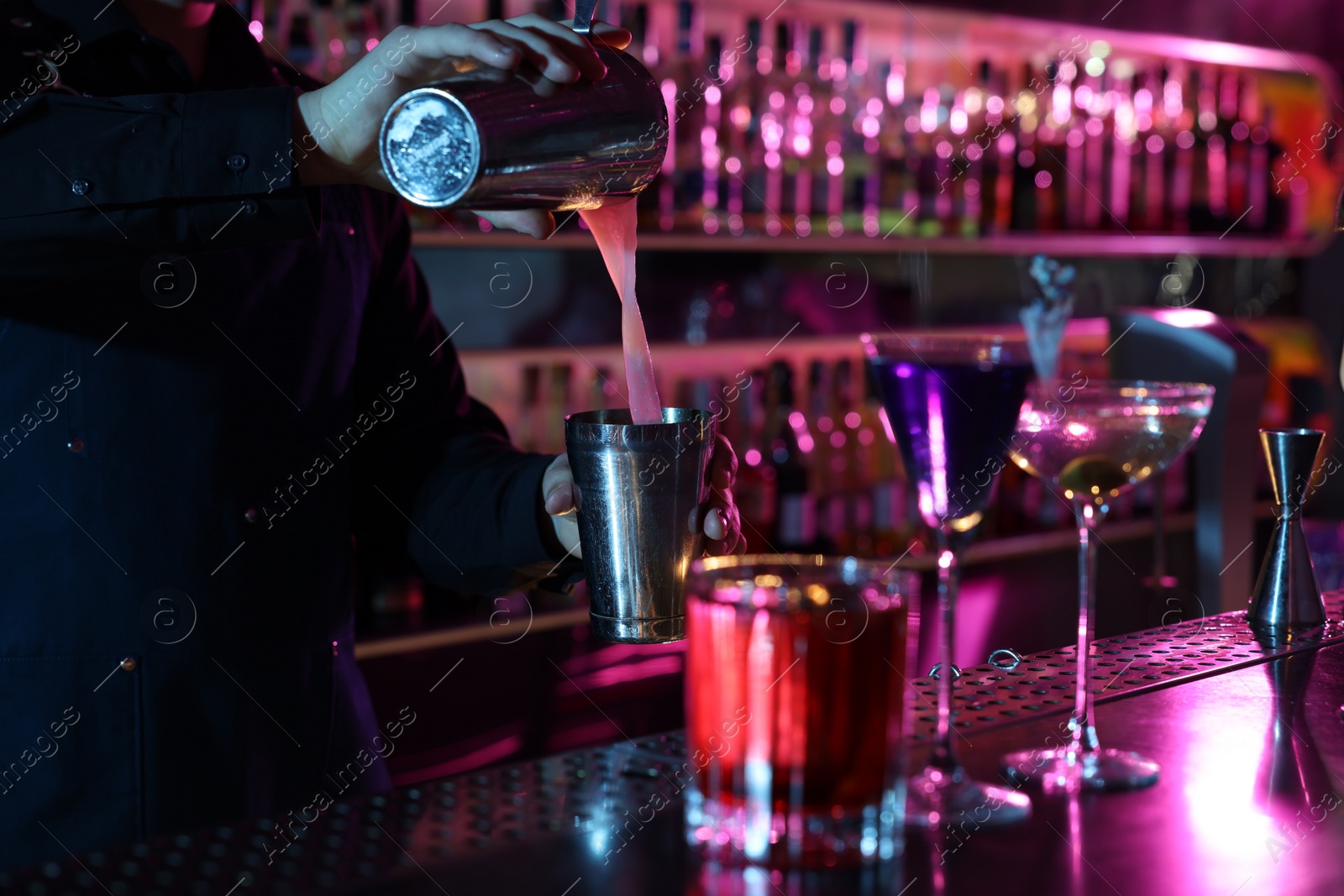 Photo of Bartender making fresh alcoholic cocktail at counter in bar, selective focus