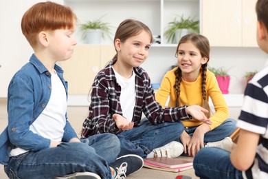 Photo of Cute children discussing in classroom at school
