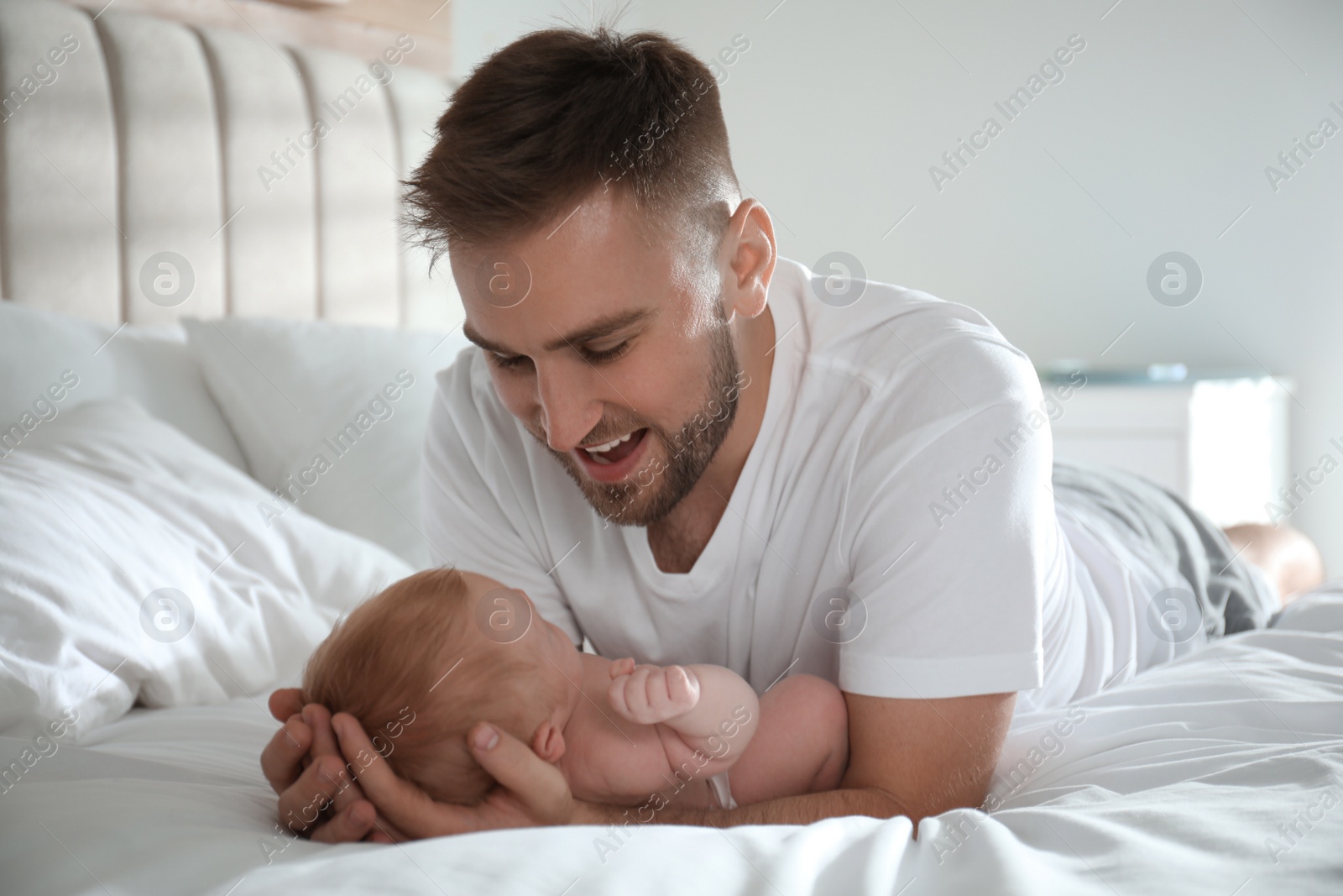 Photo of Father with his newborn son at home