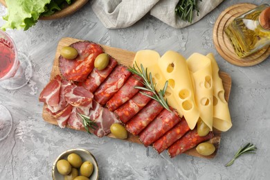 Photo of Delicious charcuterie board served on light grey table, flat lay