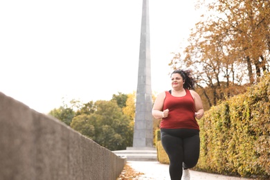 Beautiful overweight woman running in park. Fitness lifestyle