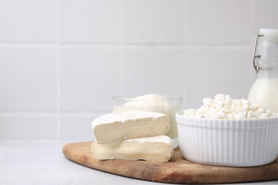 Dairy products. Different kinds of cheese and milk on light table, space for text