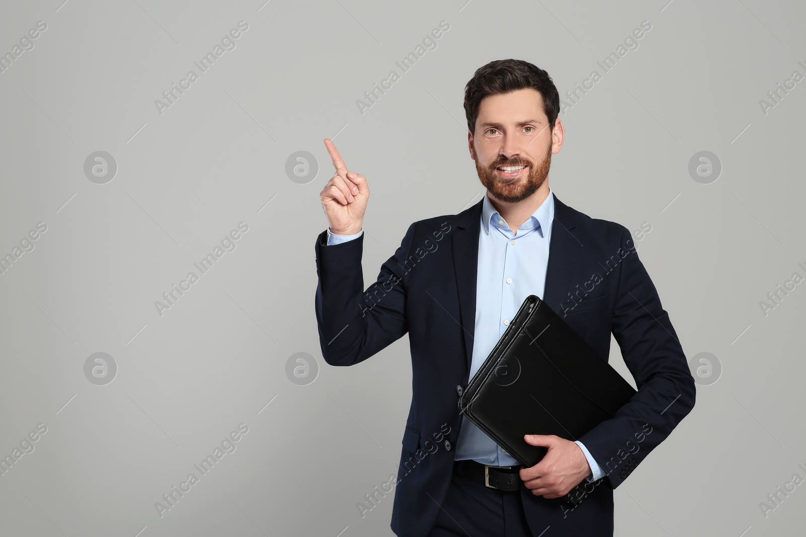 Photo of Handsome real estate agent with documents on grey background, space for text