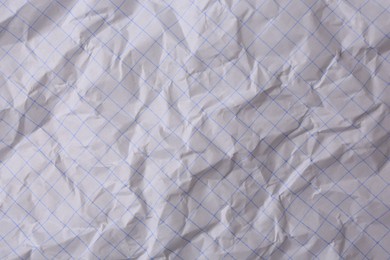 Sheet of crumpled checkered paper as background, top view