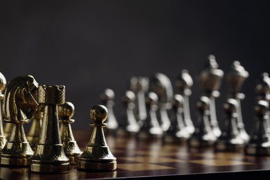 Photo of Chessboard with game pieces on grey background, closeup. Space for text