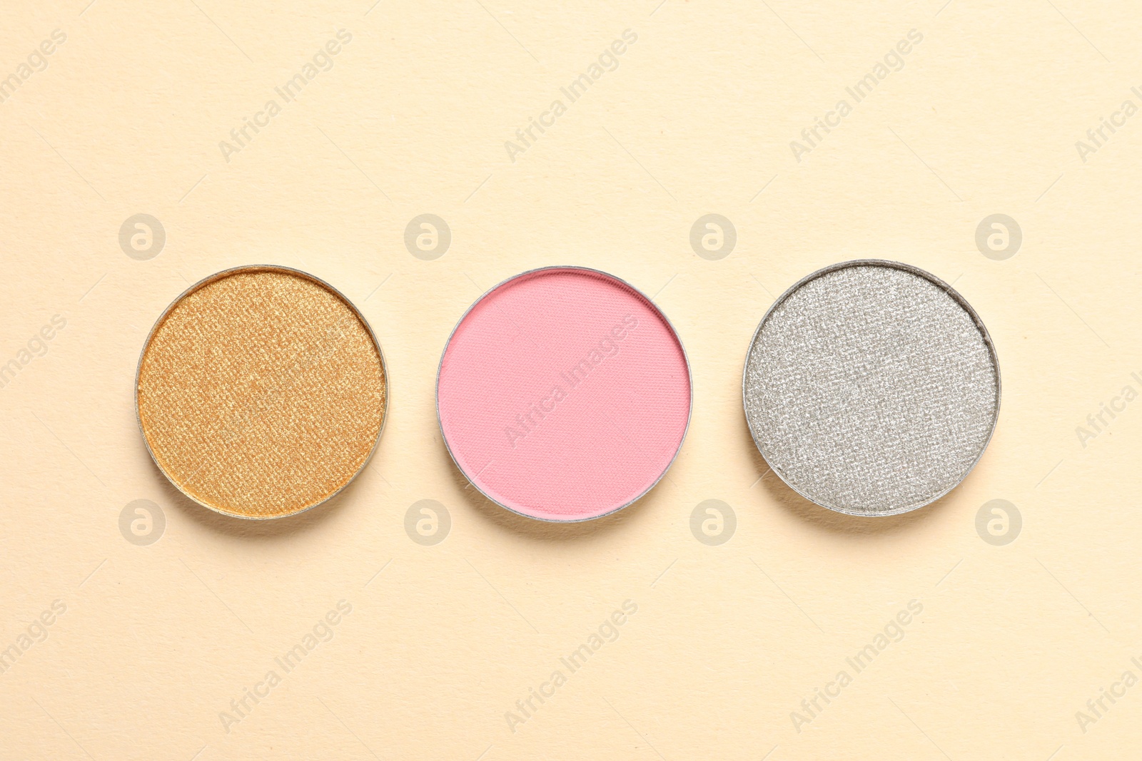 Photo of Different beautiful eye shadows on beige background, flat lay