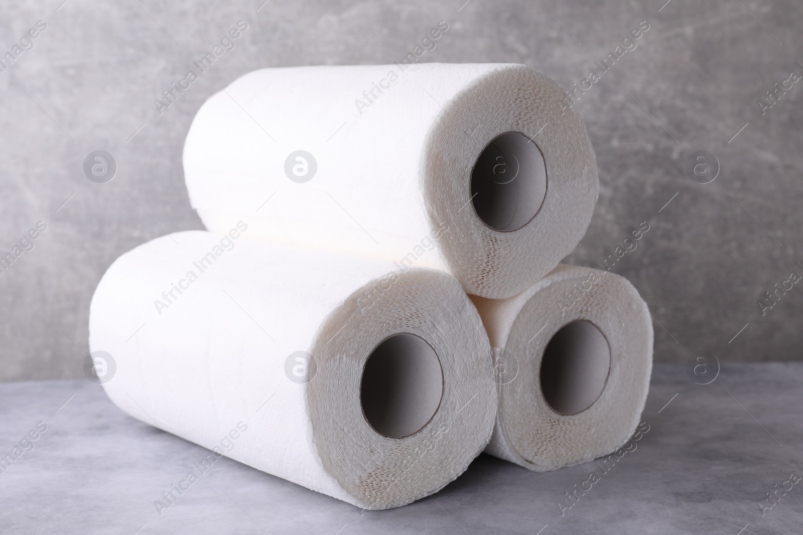 Photo of Rolls of paper towels on grey table, closeup