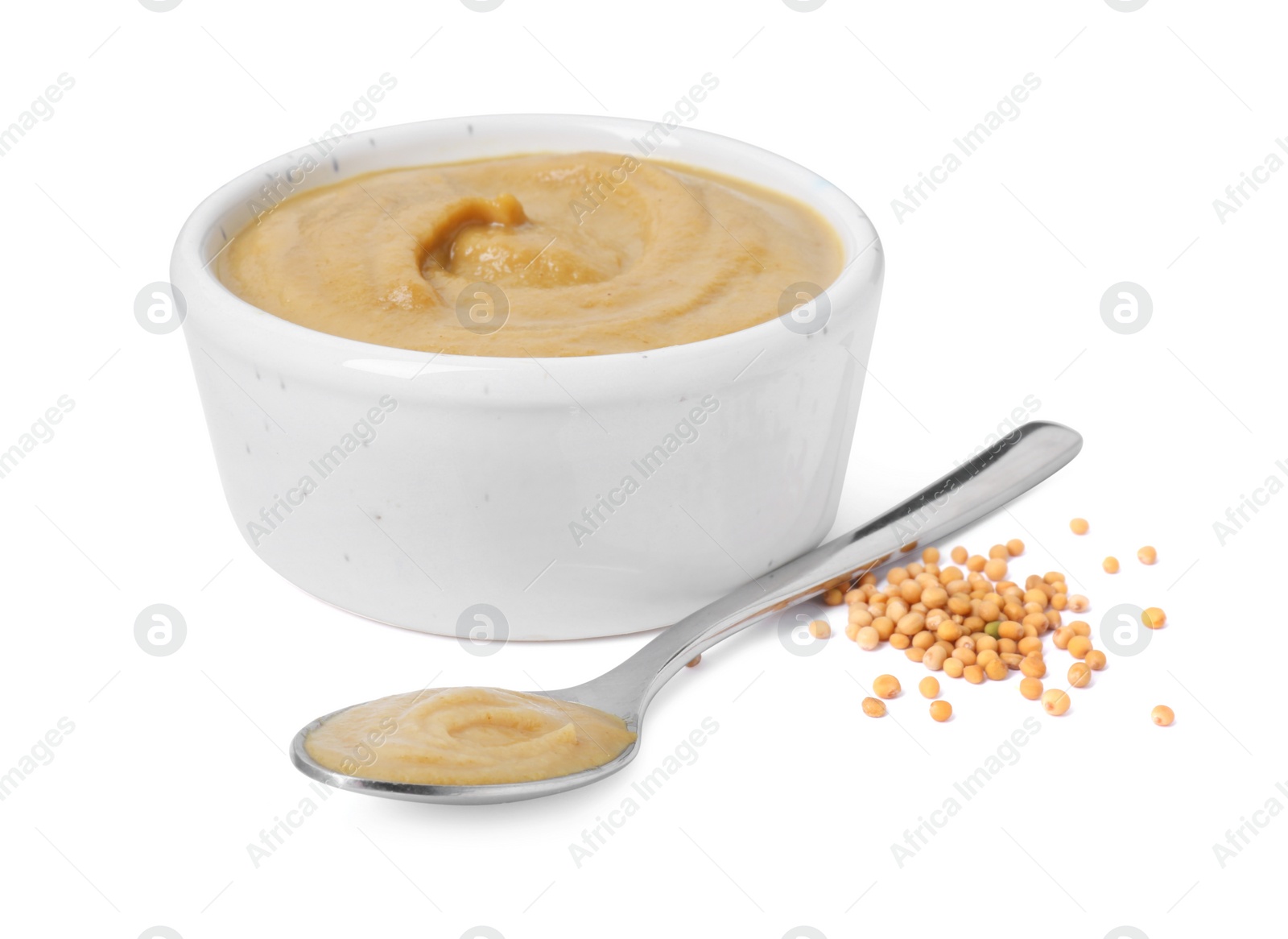 Photo of Fresh tasty mustard sauce in bowl and spoon with dry seeds isolated on white