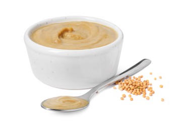 Photo of Fresh tasty mustard sauce in bowl and spoon with dry seeds isolated on white