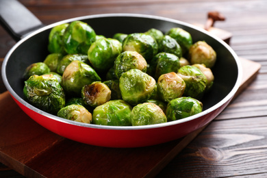 Roasted Brussels sprouts in frying pan on wooden table