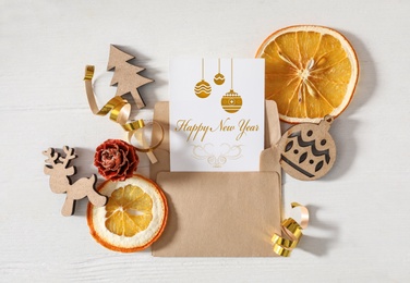 Image of Flat lay composition with greeting card on white wooden table. Merry Christmas