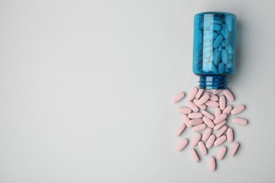 Photo of Vitamin pills and bottle on grey background, top view. Space for text