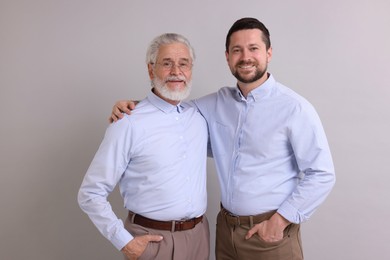 Happy son and his dad on gray background