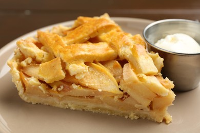 Piece of tasty homemade quince pie with ice cream on table, closeup