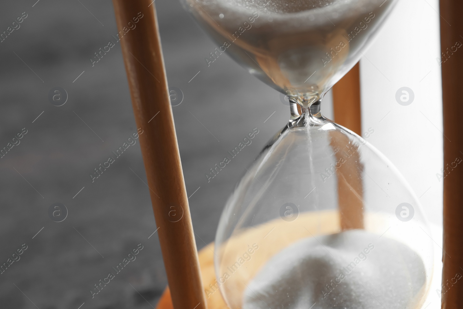 Photo of Hourglass with flowing sand on table, closeup. Time management