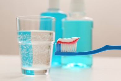 Photo of Brush with toothpaste on blurred background, closeup