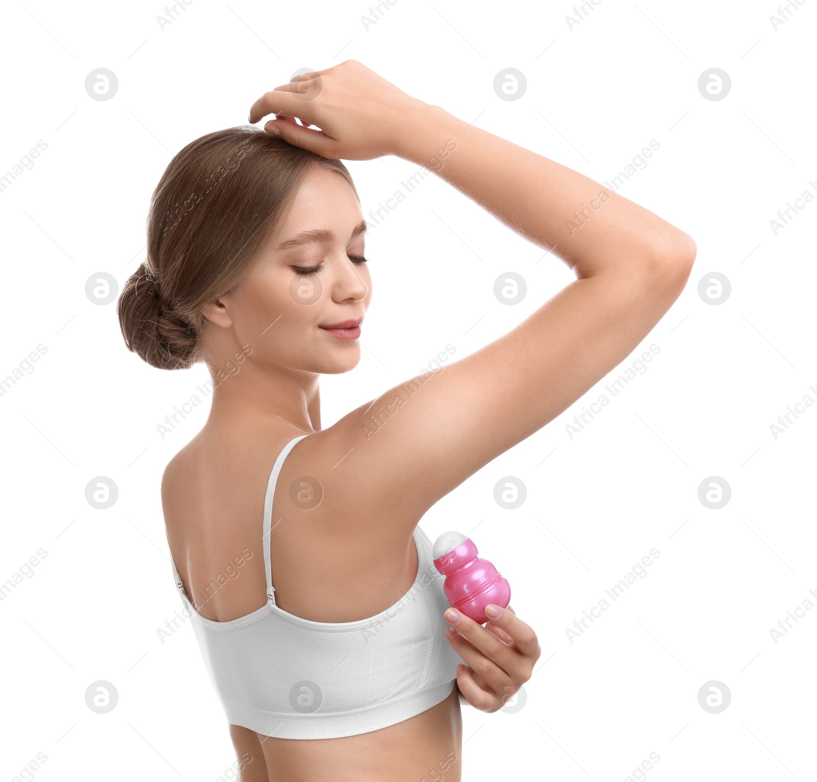 Photo of Young woman applying deodorant to armpit on white background