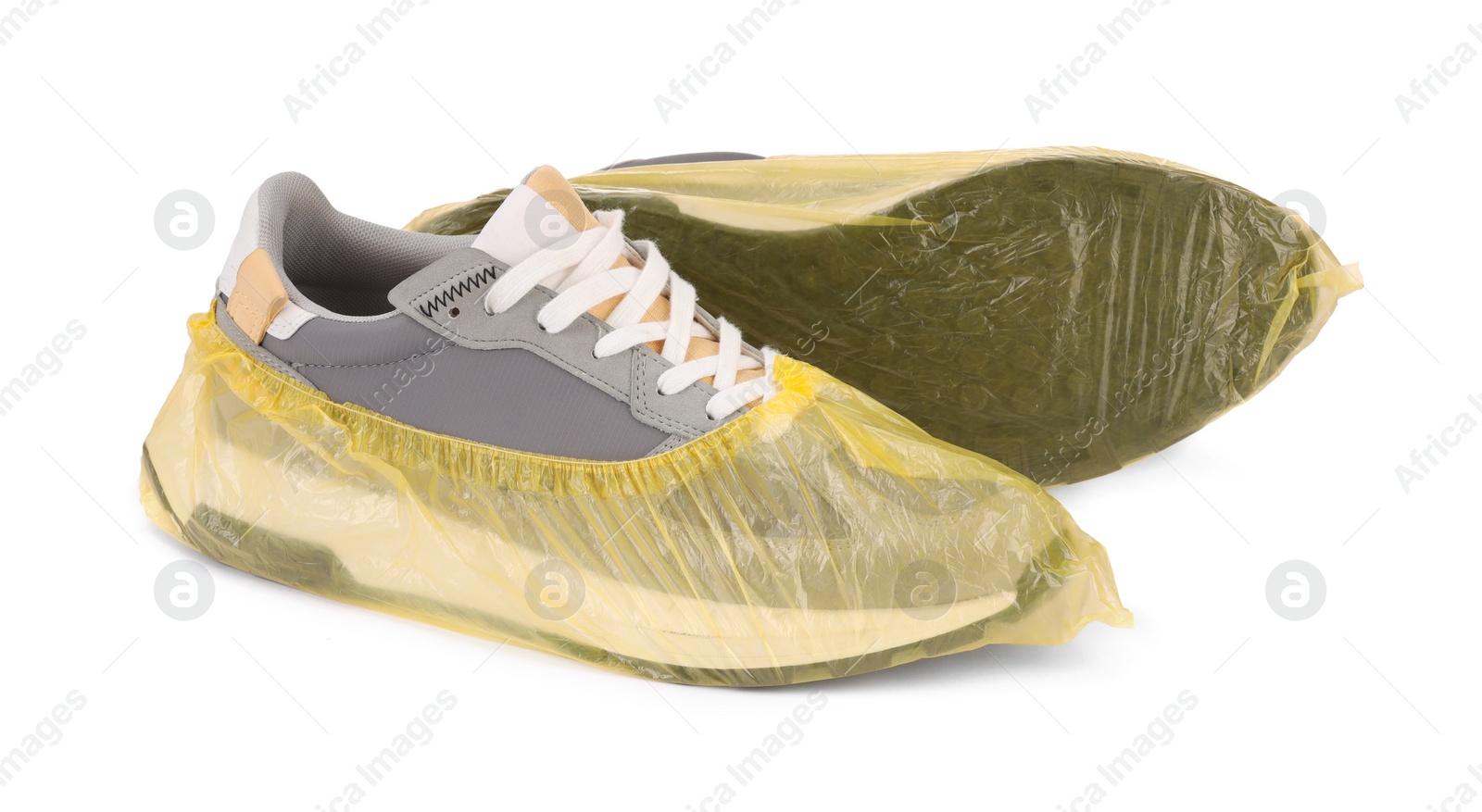 Photo of Men's sneakers in yellow shoe covers isolated on white