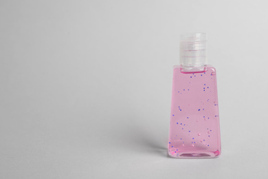 Photo of Bottle with antiseptic gel on light grey background. Space for text