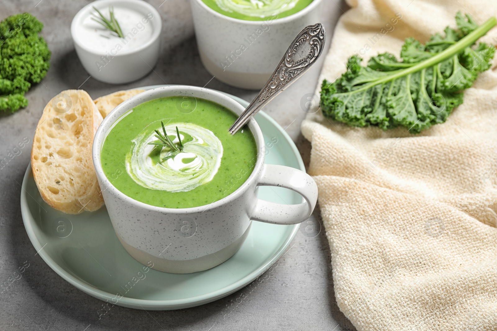 Photo of Tasty kale soup served on grey table