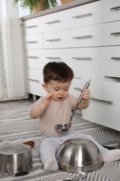 Photo of Cute little boy with cookware at home