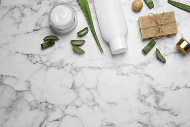 Flat lay composition with aloe vera and cosmetic products on white marble background. Space for text