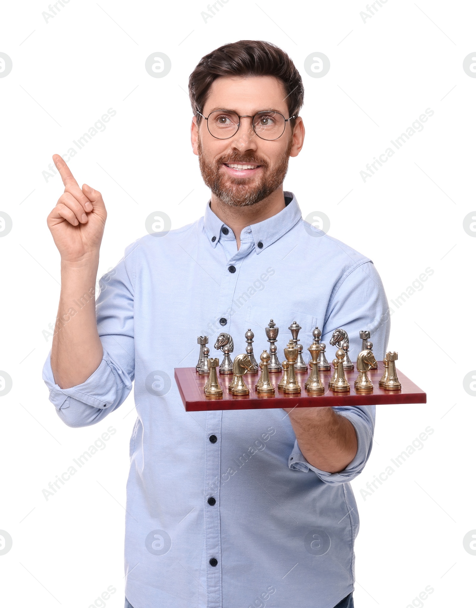 Photo of Smiling man holding chessboard with game pieces on white background