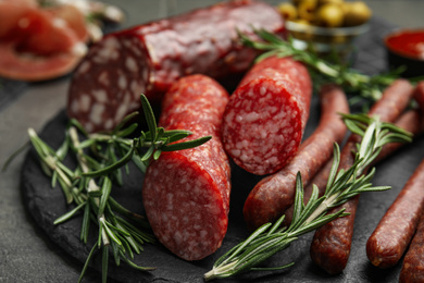Photo of Different types of sausages served on grey table, closeup