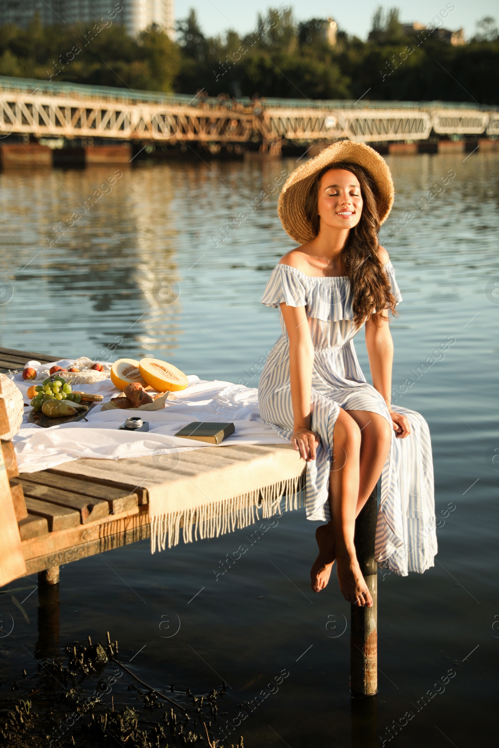 Photo of Young woman spending time on pier at picnic