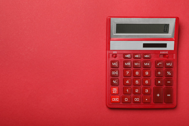 Calculator on red background, top view with space for text. Tax accounting concept