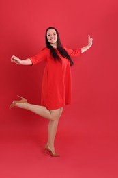 Photo of Beautiful overweight woman in dress on red background