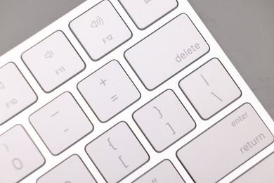 Internet shopping. Computer keyboard on grey background, top view