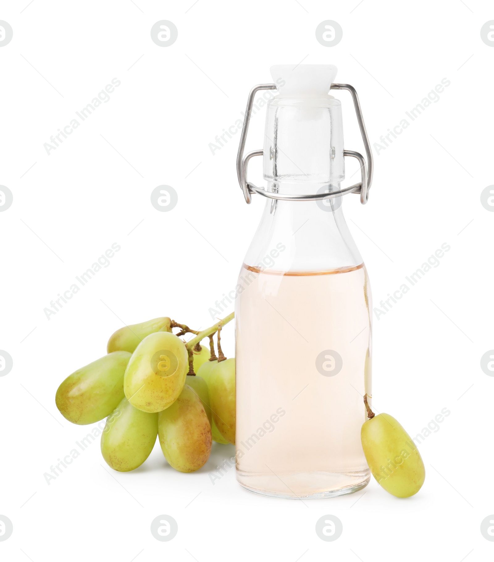 Photo of Grape vinegar in bottle and berries isolated on white