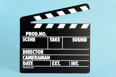 Photo of Clapper board on light blue background. Cinema production