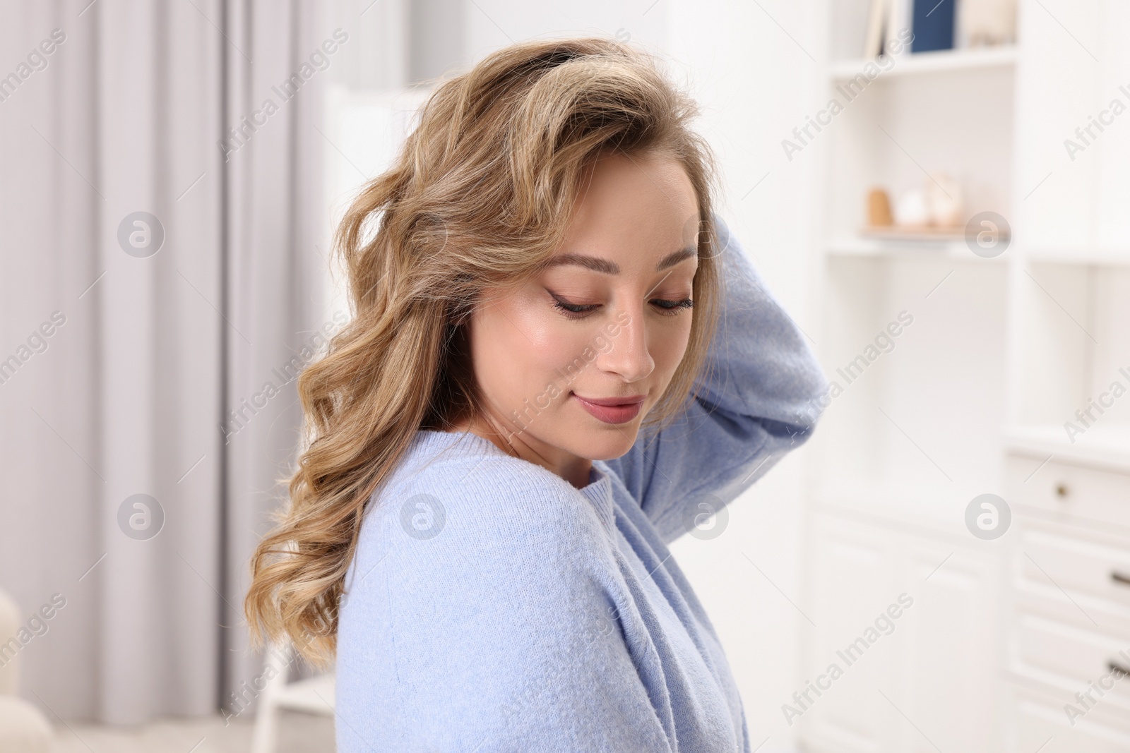 Photo of Portrait of beautiful woman with curly hair at home