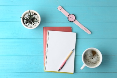 Photo of Flat lay composition with office stationery and cup of coffee on light blue wooden table