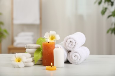 Photo of Composition with different spa products and plumeria flowers on white marble table indoors