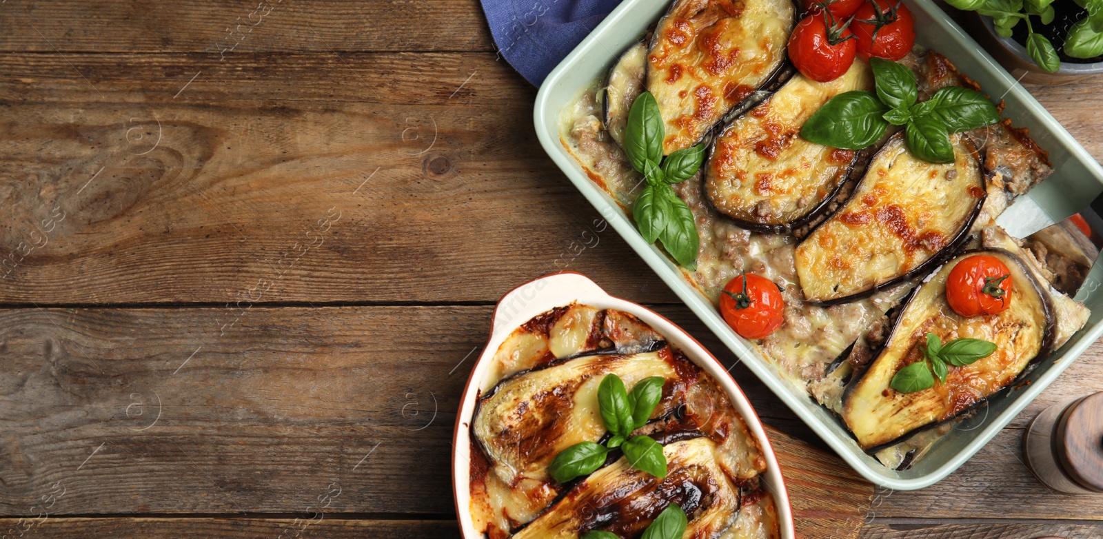 Image of Delicious eggplant lasagna in baking dishes on wooden table, flat lay with space for text. Banner design