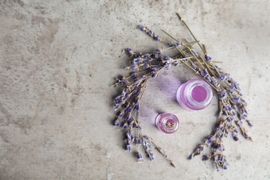 Natural herbal oil in glass bottles and lavender flowers on color background, top view. Space for text