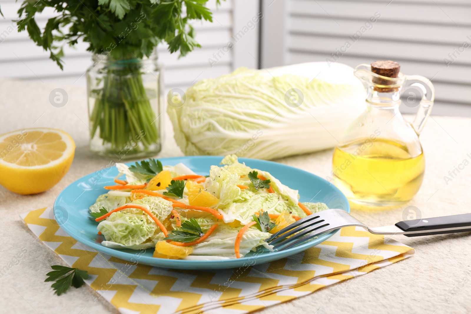 Photo of Tasty salad with Chinese cabbage, products and fork on beige table