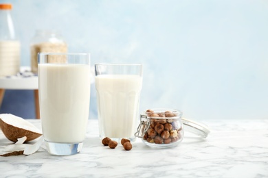 Glasses with milk substitute and nuts on kitchen table